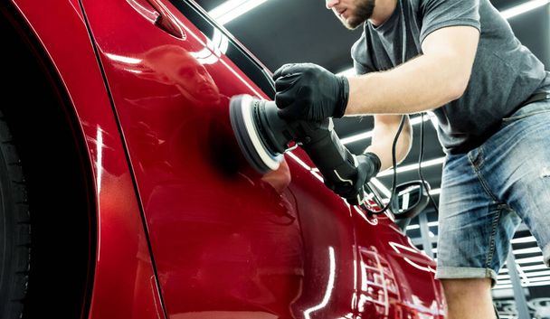 Car service worker polishes a car details with orbital polisher. - Fotoğraf, Görsel