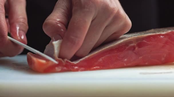 Sushi Chef affetta salmone fresco sul sushi bar. Un sushi-man affetta una bistecca di salmone con il suo coltello giapponese. Preparazione del sushi nigiri di pesce. Ricette cucina giapponese. - Filmati, video