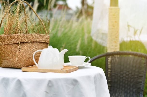 Hora do chá inglês no jardim, tempo de relaxamento com bebida favorita, xícara de chá quente e bule servindo na bela vista do prado da natureza. - Foto, Imagem