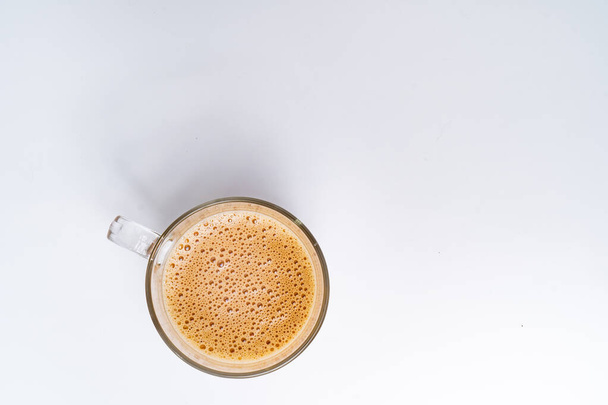 Top angle of milk tea or popularly known as The Tarik in Malaysia, isolated on the white background center of the frame - 写真・画像