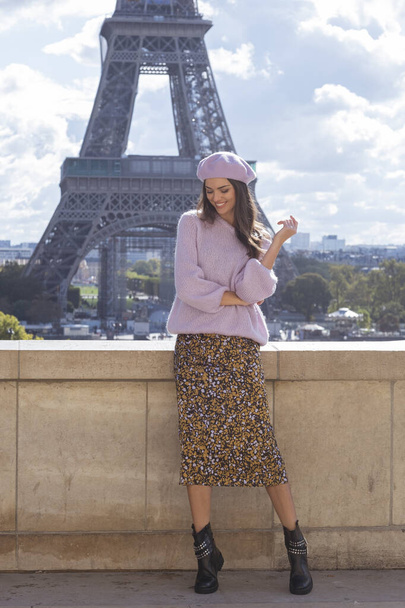 Lovely parisian look.Beautiful woman in lila beret is making memories in front of eiffel tower! How romantic. - Foto, afbeelding