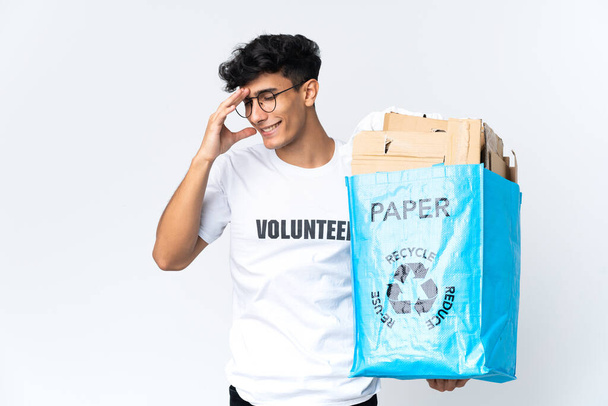 Joven sosteniendo una bolsa de reciclaje llena de papel riendo - Foto, imagen