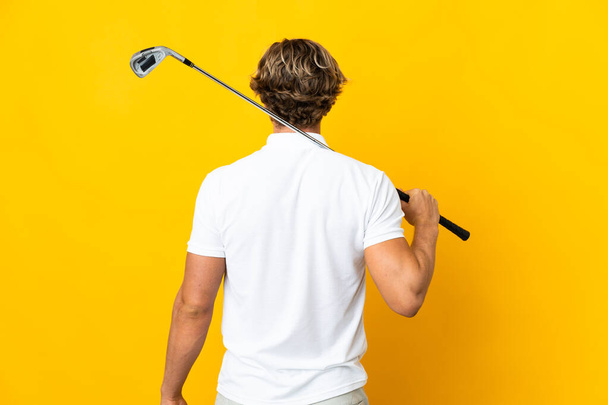 English man over isolated white background playing golf and in back position - 写真・画像