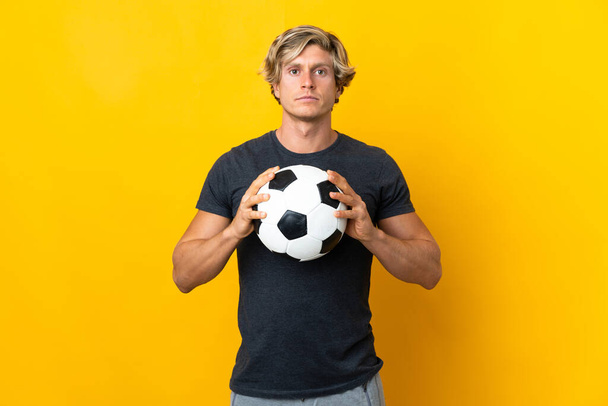 Αγγλικά άνθρωπος πάνω από απομονωμένο κίτρινο φόντο με μπάλα ποδοσφαίρου - Φωτογραφία, εικόνα