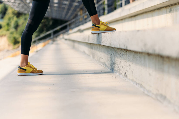 Lähikuva naisten jalat urheilu lenkkarit seisoo portaissa - Valokuva, kuva