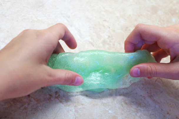 le mani dei bambini giocano con la melma verde da vicino - Foto, immagini
