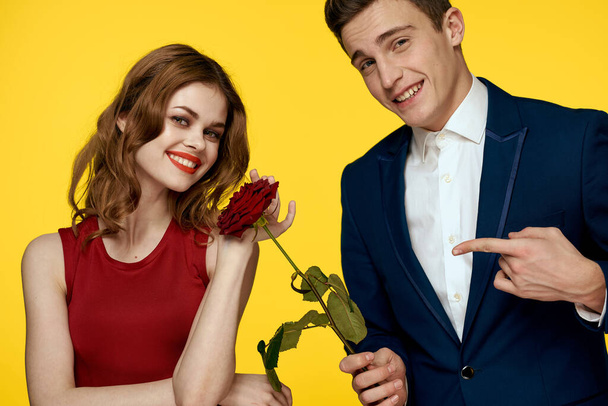 Young charming couple rose relationship romance gift as a lifestyle yellow isolated background - Photo, Image