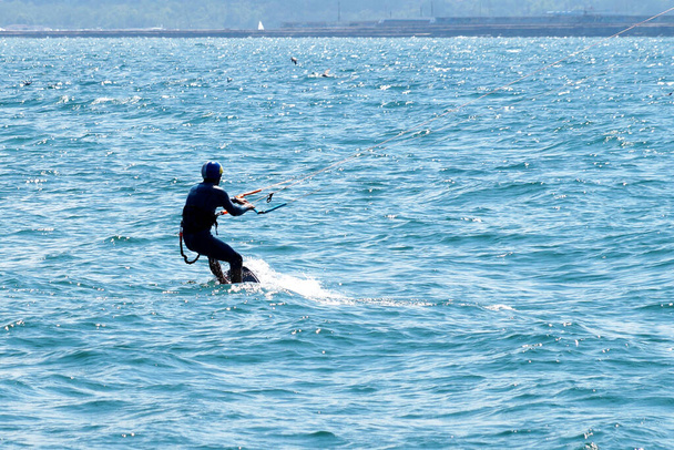 un hombre está navegando en el mar en un día soleado y ventoso. - Foto, Imagen