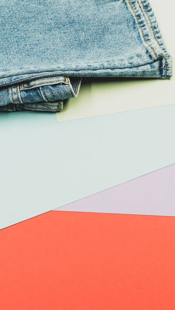 A vertical shot of a pair of jeans on a colorful surface - 写真・画像