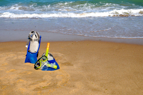ласты и маска для плавания на песке на фоне моря и ясного неба, копировальное пространство - Фото, изображение