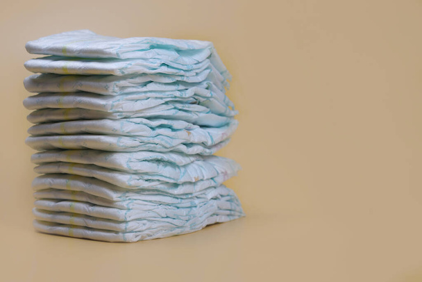pila di pannolini su uno sfondo leggero, prodotti per l'igiene del bambino - Foto, immagini