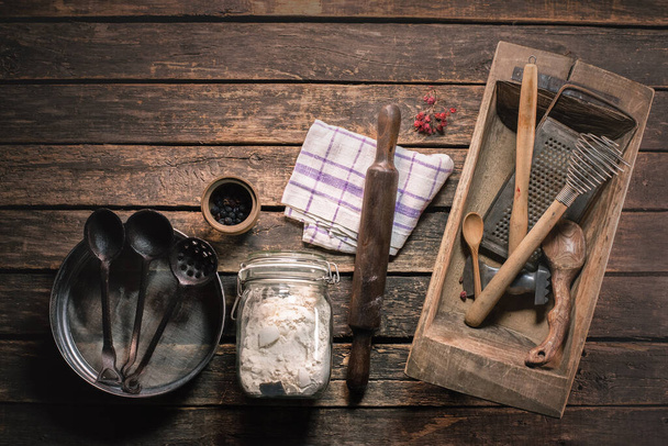 A flour in the jar and different kitchen utensils on the table background. - Photo, image