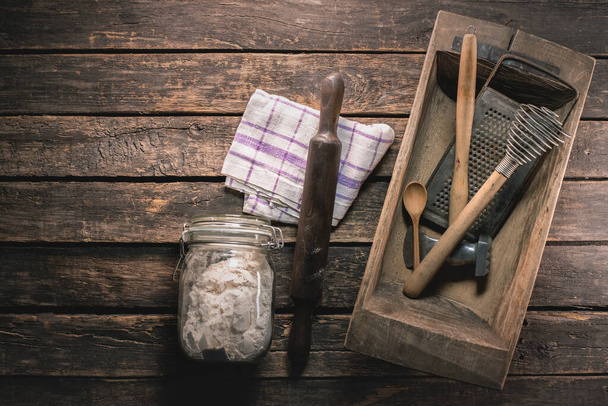 A flour in the jar and different kitchen utensils on the table background. - Foto, Imagem