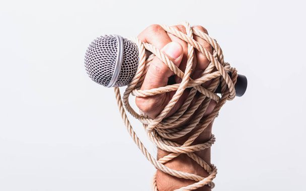 Hand holding microphone and have roped on fist hand on white background, Human rights day concept - Φωτογραφία, εικόνα