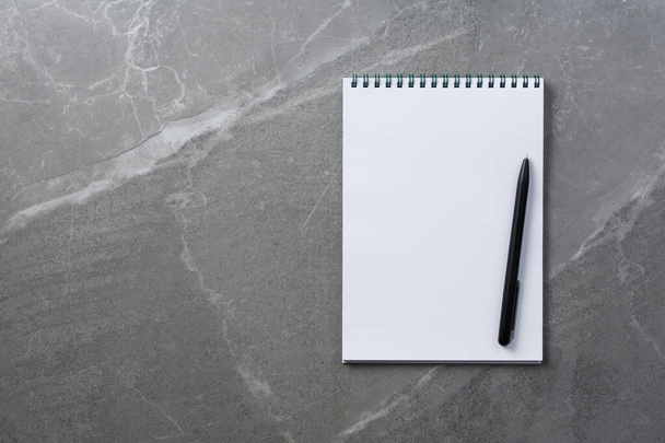 notebook with black pen on marble background - Foto, afbeelding