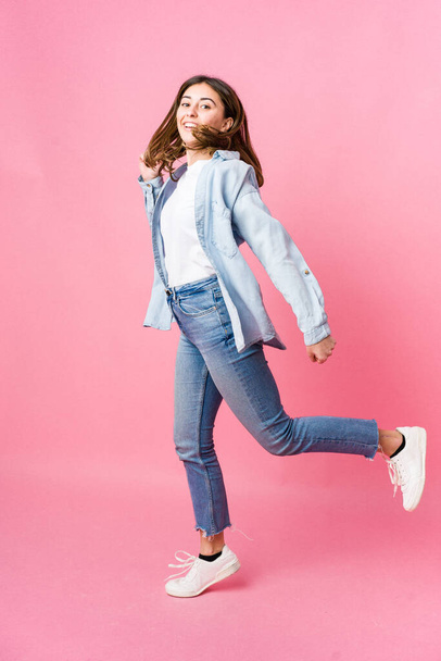 Young woman jumping on pink background - Foto, Bild