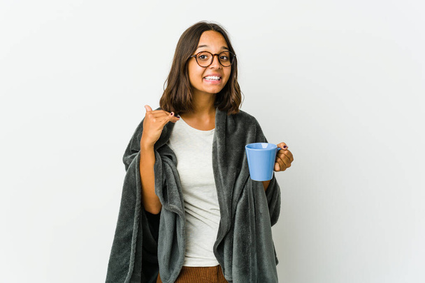 Young latin woman with blanket isolated on white background laughing about something, covering mouth with hands. - Photo, Image
