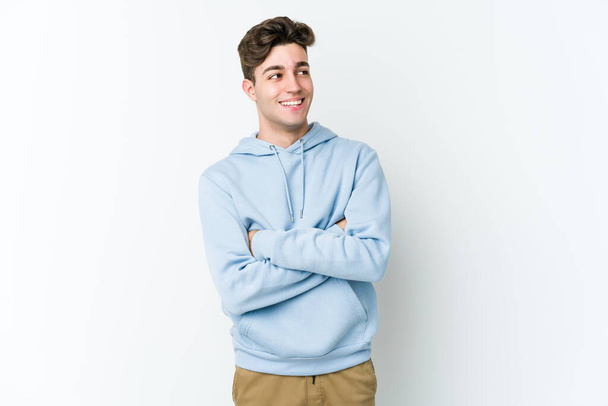 Young caucasian man isolated on white background smiling confident with crossed arms. - Photo, Image