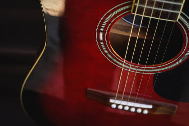 Close up of acoustic guitar on dark background in natural light. - Zdjęcie, obraz