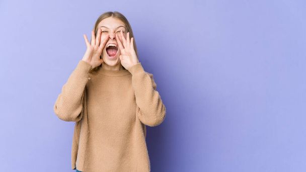 Young blonde woman isolated on purple background shouting excited to front. - Photo, Image