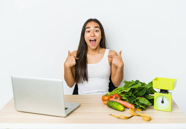 Junge Ernährungsberaterin asiatische Frau isoliert auf weißem Hintergrund überrascht zeigt mit dem Finger, lächelt breit. - Foto, Bild