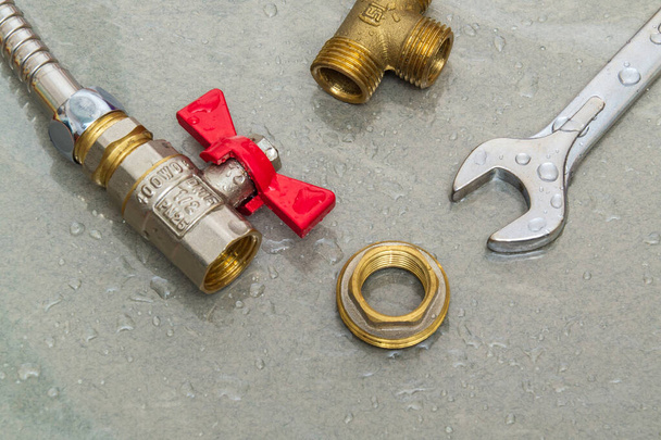 Kran i klucz hydrauliczny w kroplach wody podczas naprawy sprzętu podczas wypadku - Zdjęcie, obraz