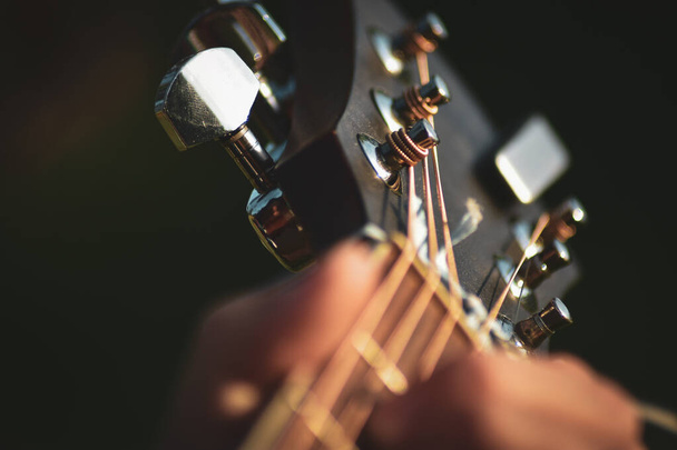 Male musician playing on acoustic guitar. Hand close up. - Foto, imagen