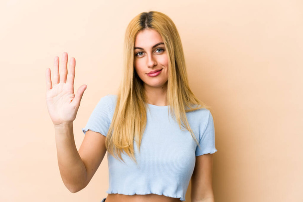 Young blonde caucasian woman smiling cheerful showing number five with fingers. - Photo, Image