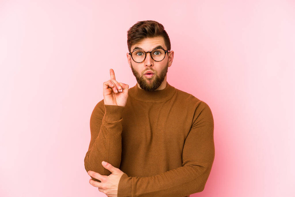 Young caucasian man isolated on pink background having some great idea, concept of creativity. - Photo, Image