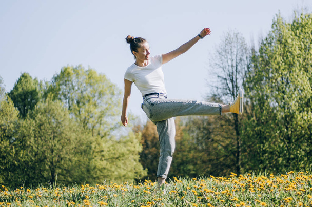Freedom concept. Happy woman jumping in city park, nice girl with good mood having fun, lifestyle - Zdjęcie, obraz