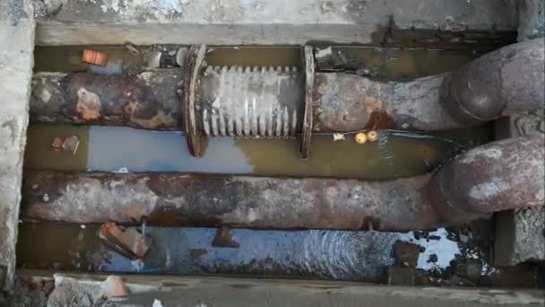 Reparatie van oude waterleidingen. Water stroomt uit het gat roestige buizen. - Video