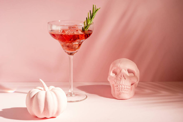 Halloween minimal concept with pink pumpkin, skull and cocktail. Creative holiday party background. - Фото, зображення