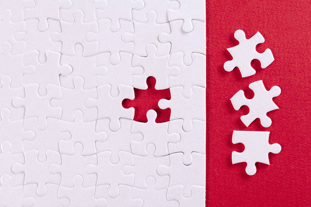 Plain white jigsaw puzzle, on Red background - 写真・画像