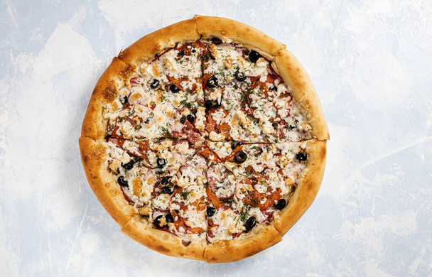 pizza op een blauwe lucht helder ontsteken achtergrond bovenaanzicht - Foto, afbeelding
