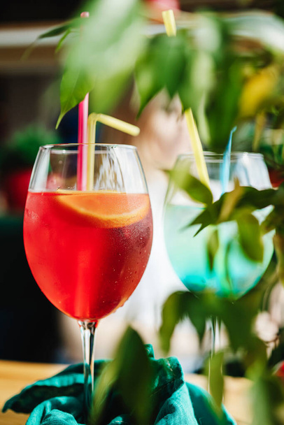 cocktail hedelmät punainen lasi viipale appelsiini vihreät lehdet etualalla - Valokuva, kuva
