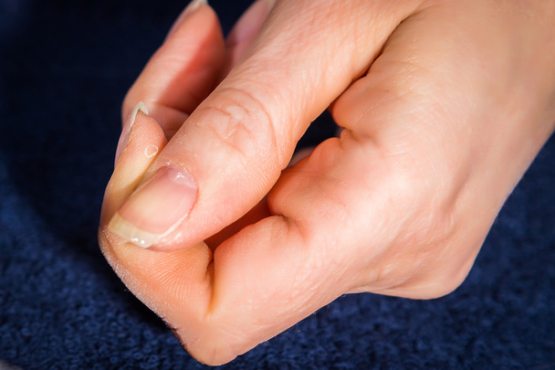 γυναικείο χέρι με άχρωμο βερνίκι για τα νύχια - Φωτογραφία, εικόνα