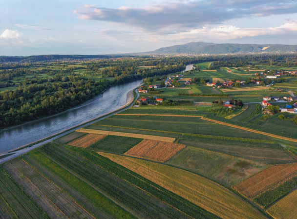 Beautiful nature and colorful cultivated crop fields on the shore of Sava river, that occasionally floods the area, photographed with drone from above - Photo, Image