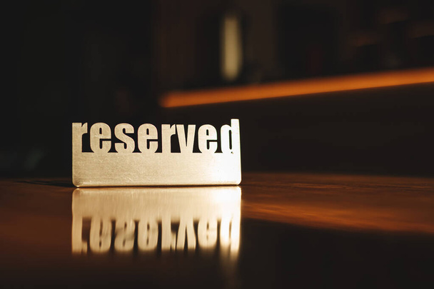 металева вивіска, зарезервована на дерев'яному столі в кафе
 - Фото, зображення