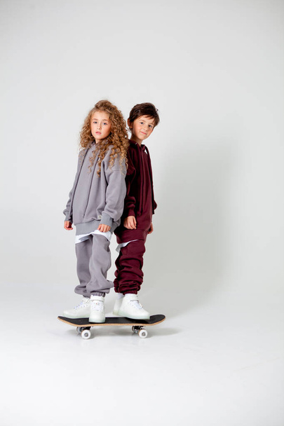кудрявая длинноволосая девочка и мальчик в спортивном костюме - Фото, изображение