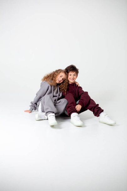 curly long-haired girl and boy in tracksuits - Foto, afbeelding