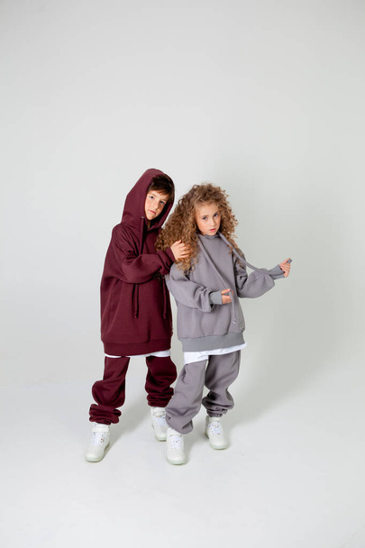 curly long-haired girl and boy in tracksuits - Фото, зображення