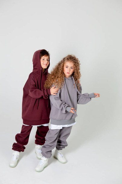 curly long-haired girl and boy in tracksuits - Foto, imagen