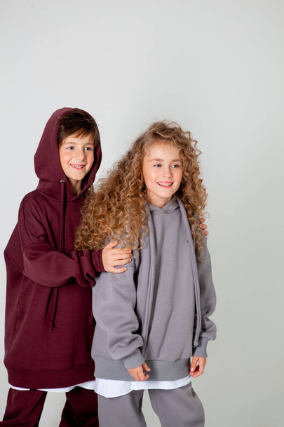 göndör hosszú hajú lány és fiú melegítőben - Fotó, kép