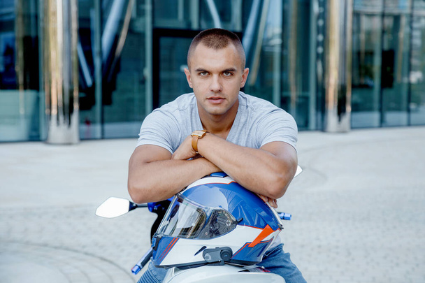 Young man on a sports motorcycle. The guy is sitting on a motorcycle. Motorcyclist. Male portrait - Foto, Imagen