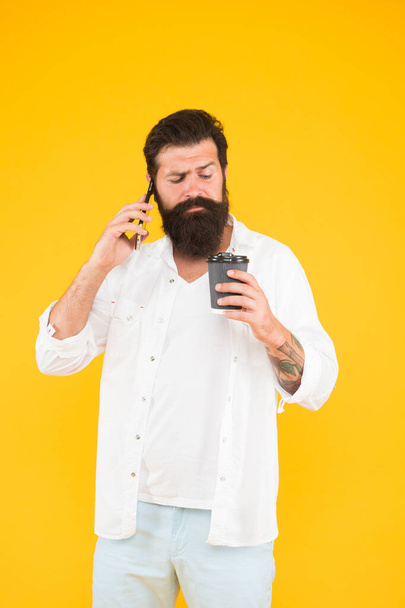 serious bearded man speaking on phone while drink coffee, morning routine - Foto, immagini
