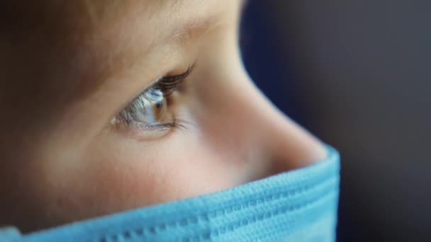 Мальчик с закрытыми глазами наблюдает за меняющимся видом за окном. Свет из окна на малыша в медицинской маске во время поездок, езды на трамвае, машине, метро. Коронавирус, COVID-19 - Кадры, видео