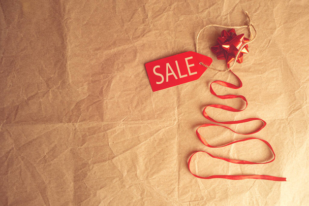 christmas tree made of ribbon with sale tag. christmas online shopping - Foto, afbeelding