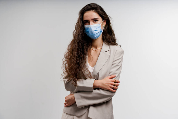 Coronavirus covid-19 quarantine concept. Girl in blue medical mask is sick covid virus isolated on white background - Фото, изображение