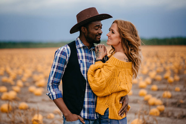 A couple of lovers stand in a pumpkin field. - Foto, imagen