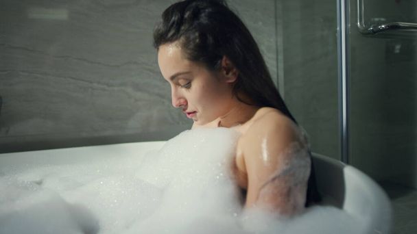 ゆったりとした女の子がロフトのインテリアでお風呂に座っています。甘いです女性休む浴槽屋内 - 写真・画像